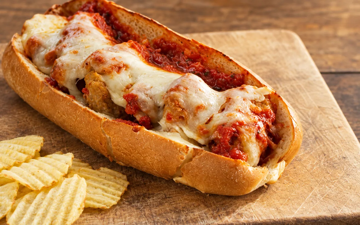 Amato’s meatball sub with melted cheese, tomato sauce, and potato chips — AI-retouched restaurant photo