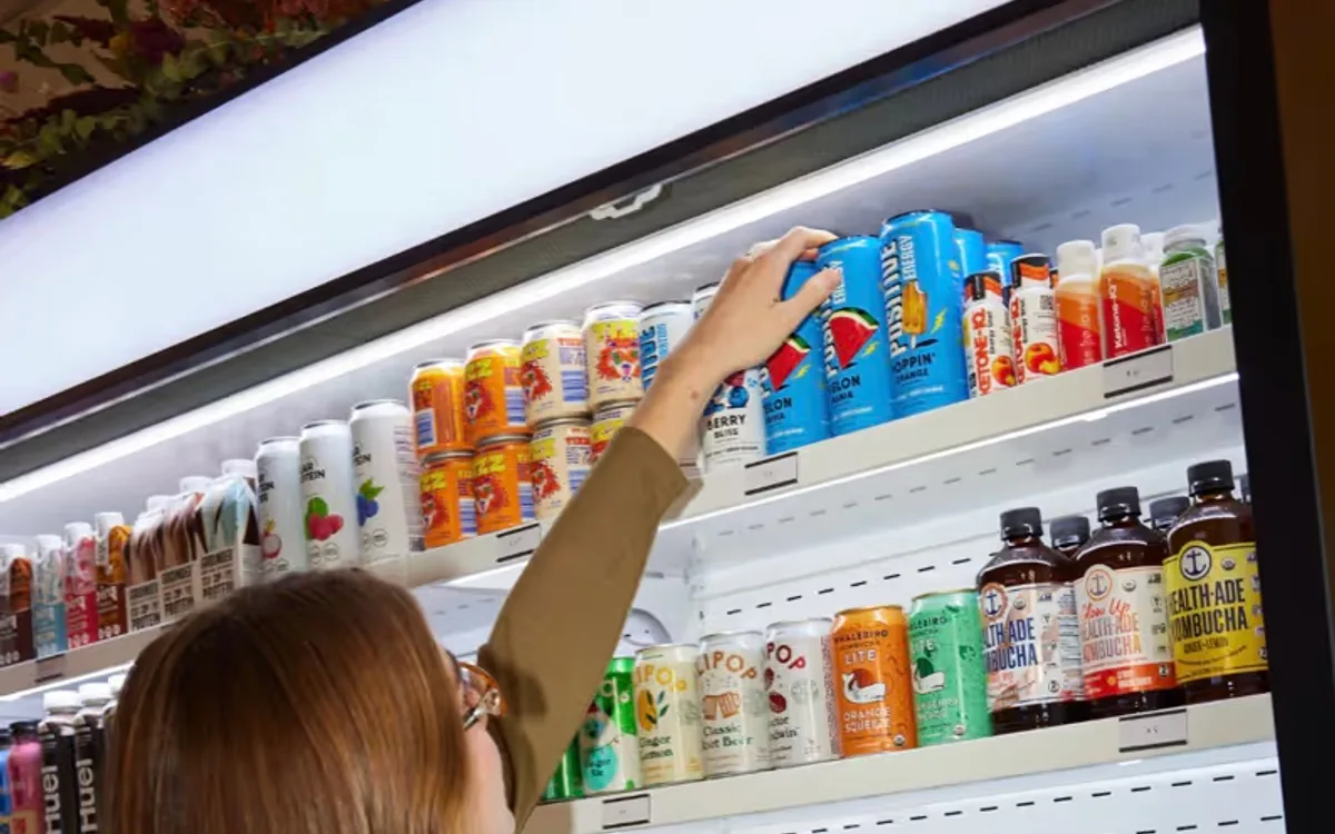 Customer reaching into the refrigerated drinks case at LB. Mini-Mart